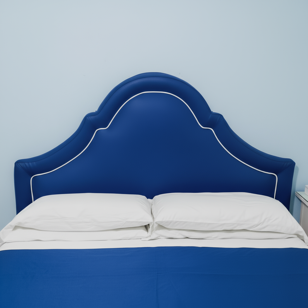 Testata letto imbottita con sagoma a "cappello di gendarme" e profilo a contrasto