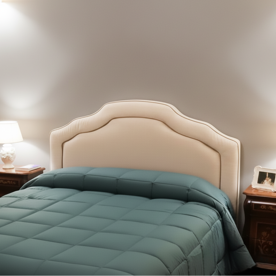 Testata letto imbottita con profilo superiore sagomato e bordatura a rilievo