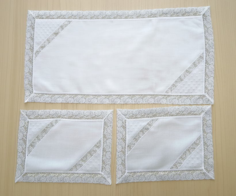 Tris di centrini bianchi con bordo e fasce merlettate